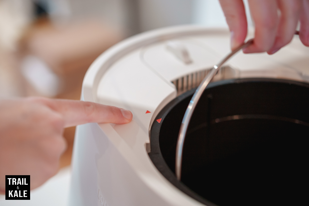 the compost bucket alignment arrows to ensure the bucket drops in place properly